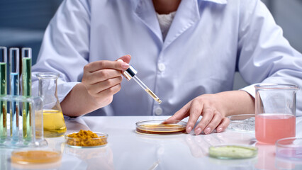 The scientist conduct an experiment of cosmetic, drop precise amount of liquid from pipette into a...