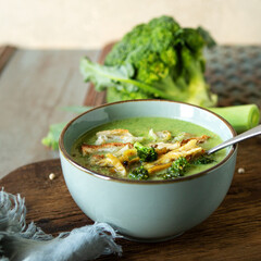 bowl of chicken cream soup with broccoli on table