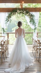 Fototapeta premium The bride admires her surroundings in a stunning white gown, surrounded by rustic decor and lush greenery in a charming wedding venue