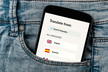 Language translator app displayed on a smartphone screen peeking out of a jeans pocket. 