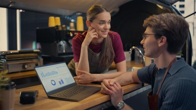 Street Cafe Manager and Female Barista Using Laptop Computer with a Financial Reporting Software at a Food and Coffee Truck, Discussing Business Strategies and Commercial Opportunities