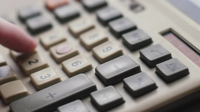 close up finger pressing calculator buttons, vintage push button calculator macro, accounting concept, budget and expense planning, financial reporting