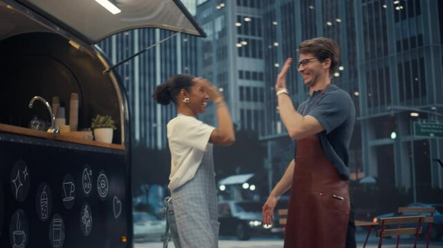 Female and Male Street Cafe Staff Members Congratulating Each Other with a High Five for Opening a Food and Drinks Truck. Young Diverse Couple Posing for Camera and Smiling