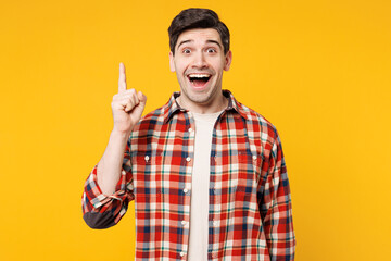 Young insighted smart proactive happy Caucasian man wears red checkered shirt casual clothes holding index finger up with great new idea isolated on plain yellow orange background. Lifestyle concept.