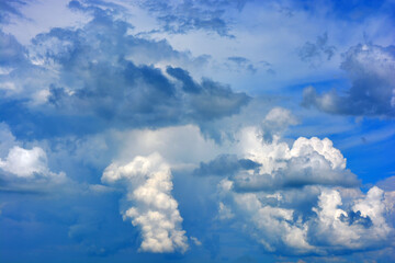 Beautiful nature, bright and colorful weather. Large bright white, fluffy clouds against a beautiful blue sky.