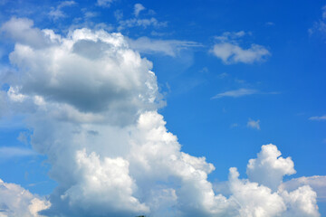 Beautiful nature, bright and colorful weather. Large bright white, fluffy clouds against a beautiful blue sky.