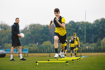 Junior Football Club Practice Session. Youth Sports Player Running on Training Field. Teenagers in...