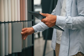 Digital tablet in hand. Man is in the hardware shop
