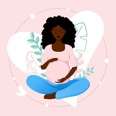 African american pregnant woman in lotus pose tenderly holds her belly on pink floral background	
