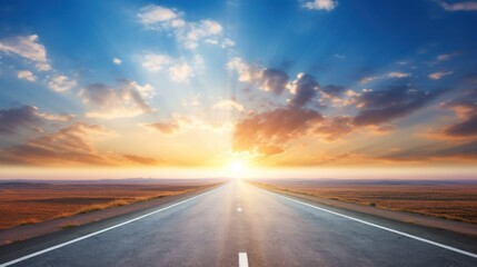 Fototapeta premium A long, straight road stretching towards the horizon under a sunrise, with a clear blue sky and fluffy white clouds.