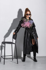 beautiful girl in black clothes with a large bouquet of flowers posing in the studio on a white background
