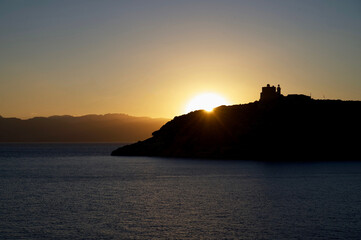 Sardinia mesmerizing sunset silhouettes an ancient castle perched atop dramatic coastal cliffs