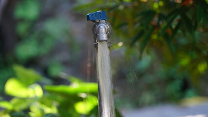 The water tap is flowing water rapidly. Focus selected. Blurred background