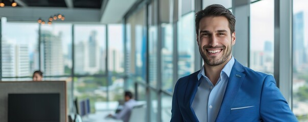 Businessman in a blue suit, smiling, against a modern office interior with panoramic windows and cityscape view, close-up with copy space on the right.