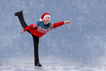 Boy figure skater in Santa Claus hat skating on ice. © Maria Moroz
