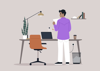 An individual in a purple shirt thoughtfully reviews a document while standing by a stylish desk in a contemporary office