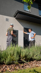 Technician discussing heat pump setup with homeowner in the garden.