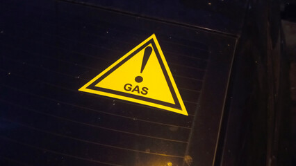 The car icon runs on gas fuel. Types of fuel for cars. The concept is the use of gas fuel. The gas symbol on the car window at night. Photo 16:9.