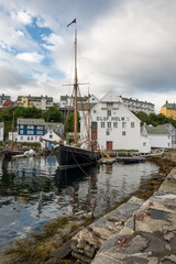 View of sailing ships in the harbor of &Aring;lesund in Norway.