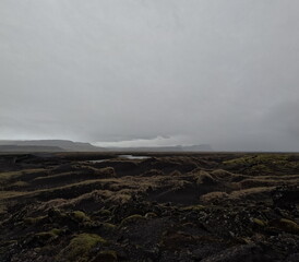 A brightened Icelandic volcanic landscape with moss-covered terrain under low clouds. Enhanced brightness and contrast reveal the stark beauty of Iceland’s wild nature.