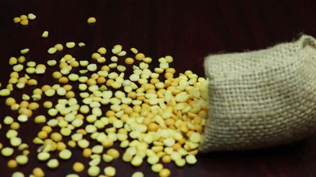 Pigeon pea legume or Arhar-toor dal scatter from a bag on board. Slow motion. 
