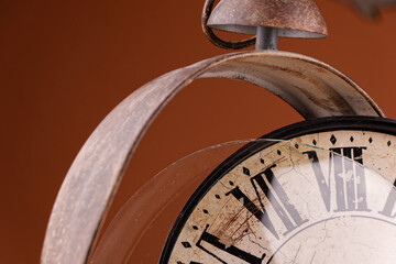 Broken old analog clock with glass and metal frame on wooden table, broken structure