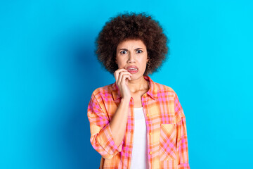 Photo portrait of pretty young girl bite nails frightened wear trendy plaid outfit isolated on blue...