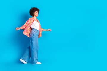 Full body photo of pretty young girl walk elegant wear trendy plaid outfit isolated on blue color background