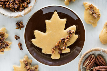 Maple pecan shortbread cookies with a large maple leaf shaped one on a plate.
