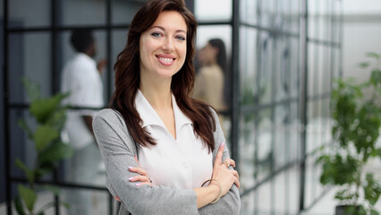 Confident young woman in a closed pose. Office professions