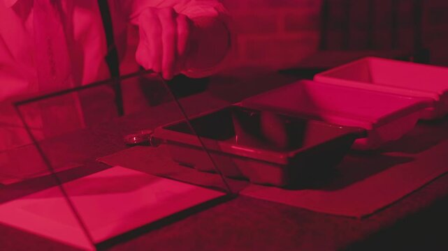 vintage man exposing film and developing in his darkroom