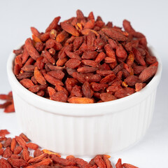 Dried Goji berries in a plate on a white background