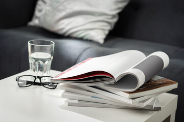 Eyeglasses with stack of books, and the glass of water on the table