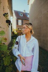 Portrait of attractive caucasian woman fashion model in glasses, posing outdoor in summer sunny day