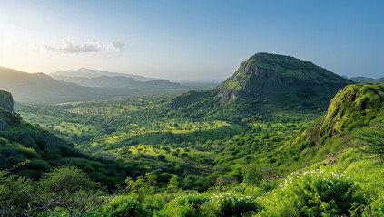 a dome mountain surrounded by a lush, green valley and a clear sky