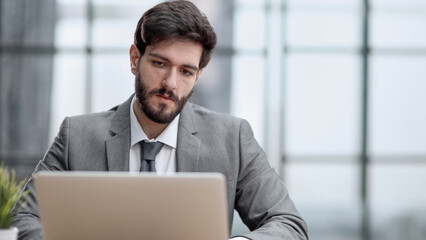 Successful businessman working inside office, man in business suit working at workplace with documents and laptop