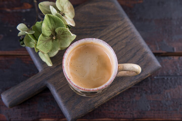 Espresso in a small ceramic mug on a wooden table