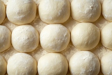 Fototapeta premium Dough balls on a floured surface. This image is perfect for showcasing the process of making bread or pizza.