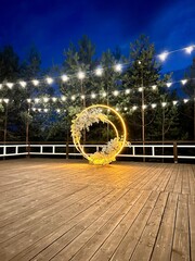 A platform with an arch and with hanging decorative lamps for the night ceremony
