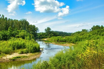 Sunny Summer day landscape of a small creek winding through forests and fields in Northern Illinois.