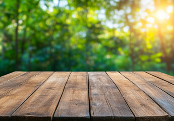 Empty wooden table in front of a blurred green forest background with sunlight streaming through, creating a serene outdoor setting.