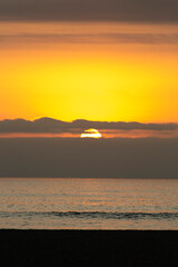 Sunset in Arica, Chinchorro beach, the sun slowly sets between the clouds, on a winter day