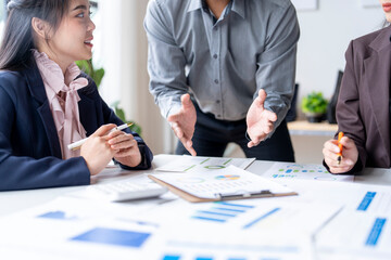 Business team leader explaining charts and graphs to colleagues during meeting
