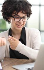 Portrait of Young Successful Caucasian Businesswoman Sitting at Desk Working on Laptop