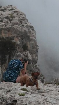 Fot&oacute;grafo encuadra el paisaje y la perrita que la acompa&ntilde;a camina en el parque natural sierra de Mariola, Alcoy, Espa&ntilde;a