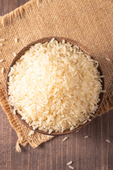 Uncooked white rice in a wooden bowl. Healthy cereal concept.  