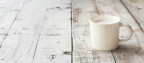 Mug of milk on a white wooden table with copy space image.