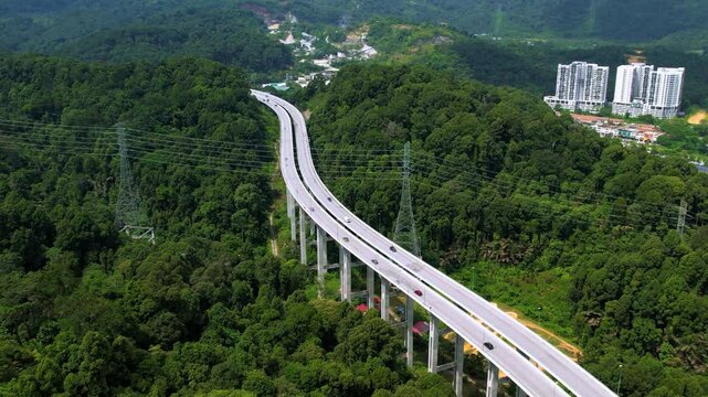 Aerial view of the Tree Giam Kanching bypass highway winding through the mountains of Rawang, Selangor, Malaysia surrounded by greenery.
