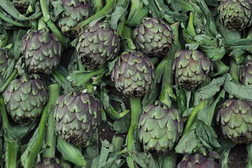 Obraz premium Verdure esposte . Carciofi, limoni, melanzane, aglio, cipolle, pomodori, funghi, arance, cachi, carote, mele, broccoli, patate