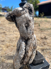 Fototapeta premium Burnt wooden sculpture of a headless human figure. Decorative object for design. Outdoor statue.